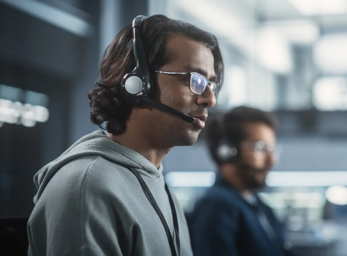 Two contact center agents wearing headsets at work