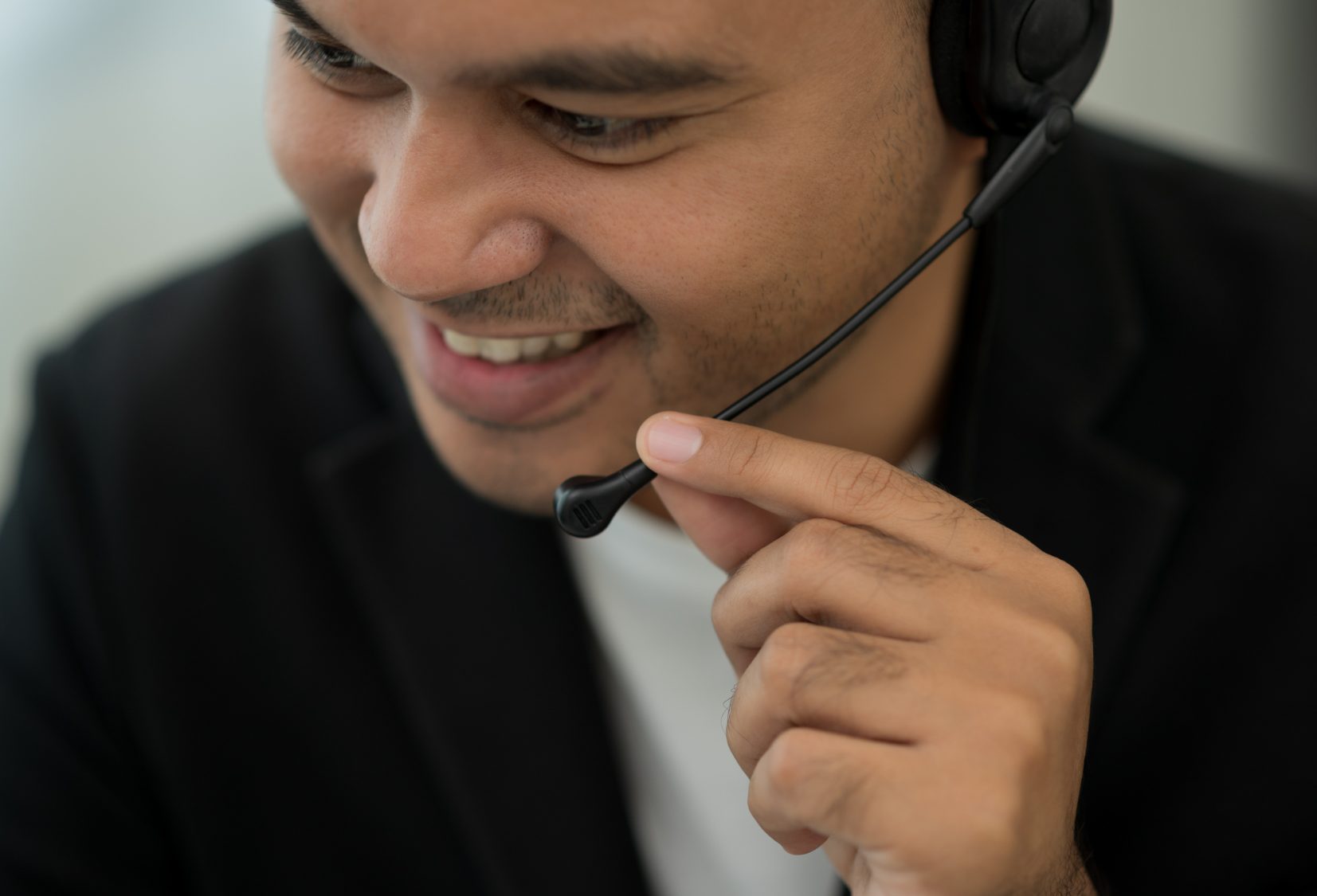 A support agent adjusting the microphone on a headset